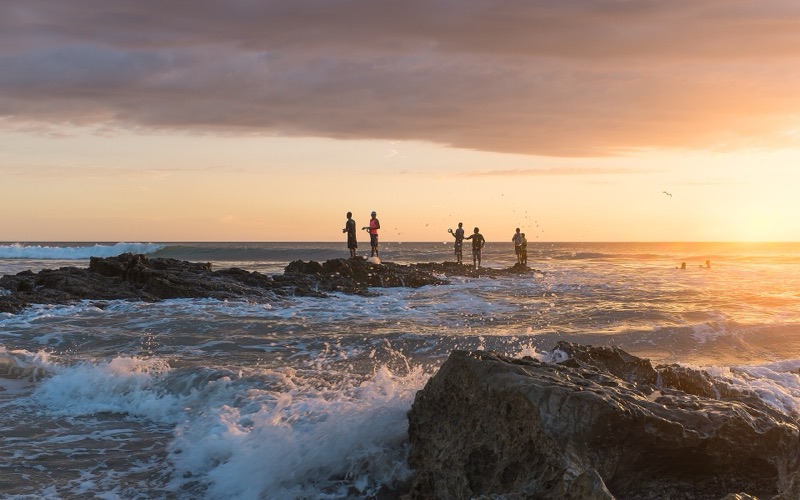 Fishermen on the rocks at sunset, Playa Santa Teresa, Costa Rica