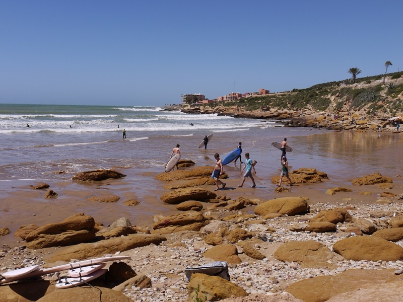 Surfers on the rocky beach at Taghazout, near Tamraght, Morocco