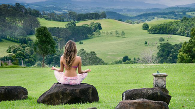 woman meditating in a green field
