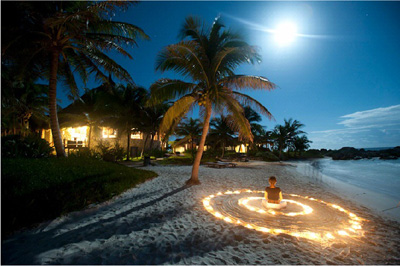 woman meditating on a beach at dusk